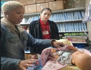 Photo of IUPUI student teaching new mother about life saving techniques. 